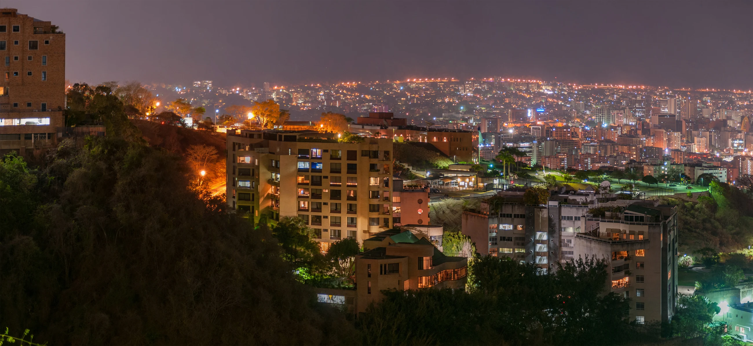 Panorámica nocturna de Caracas con edificios y luces de la ciudad